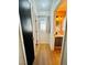 Hallway with wood-look floors leading to a bright bathroom with gray vanity and brushed gold fixtures at 6449 Stone Dry Ave # 101, Henderson, NV 89011