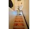 Stairway with wooden steps, white risers, and a black handrail leading up to a baby gate at the top of the stairs at 6449 Stone Dry Ave # 101, Henderson, NV 89011