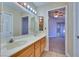 Bathroom with double sinks, a large mirror, and access to a bedroom at 6617 Old Newbury Ave, Las Vegas, NV 89108