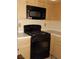 Black microwave and range, light wood cabinets at 6617 Old Newbury Ave, Las Vegas, NV 89108