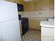 Galley kitchen with wood cabinets, black appliances, and tile floor at 6617 Old Newbury Ave, Las Vegas, NV 89108