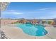 Inviting pool with a rock waterfall feature surrounded by lush landscaping, creating a backyard oasis for relaxation and enjoyment at 6914 Willowcroft St, Las Vegas, NV 89149