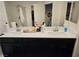 Bathroom featuring a double sink vanity with dark cabinets and a large mirror at 7050 Fossil Rim St, Las Vegas, NV 89084