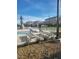Community pool area featuring lounge chairs, umbrellas, and lush landscaping at 7050 Fossil Rim St, Las Vegas, NV 89084