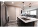 Modern kitchen with island, stainless steel sink, and view to living room at 7122 Rocket Launch St, North Las Vegas, NV 89084