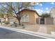 Tan two-story house with a walkway and gate at 7307 Iron Oak Ave, Las Vegas, NV 89113