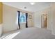 Bright bedroom with neutral walls and carpet, featuring a window with curtains and an adjacent door at 8157 Amy Springs St, Las Vegas, NV 89113