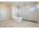 Spa-like bathroom with a freestanding tub, large glass shower, and marble flooring at 8224 Skye Territory St, Las Vegas, NV 89166