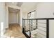 Bright hallway featuring wood floors, modern railing and trim, and a view into another room with a sliding barn door at 8224 Skye Territory St, Las Vegas, NV 89166