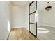 Bright room with wood floors and a modern glass and black trim sliding door leading to another adjacent room at 8224 Skye Territory St, Las Vegas, NV 89166