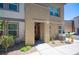 Tan two-story townhome with red door and landscaping at 9131 Hitmaker St, Las Vegas, NV 89113