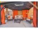 Covered patio with comfortable wicker furniture and orange curtains at 9131 Sangria Ln, Las Vegas, NV 89147