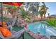 Enjoy this large pool with red umbrella and lounge chairs at 9131 Sangria Ln, Las Vegas, NV 89147