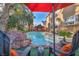 Pool area with red umbrella, lounge chairs, and a view of the house at 9131 Sangria Ln, Las Vegas, NV 89147