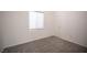 Spacious bedroom with gray carpeting and a window with blinds at 10009 Dusty Winds Ave, Las Vegas, NV 89117