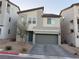 Two-story house with gray siding, gray garage door, and paved driveway at 10411 Rose Palisade St, Las Vegas, NV 89141