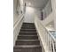 Modern staircase with white railings and gray carpeting at 10411 Rose Palisade St, Las Vegas, NV 89141