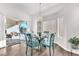 Bright dining area with a glass table, modern light fixture, and sliding glass doors to a covered patio at 10725 Sky Meadows Ave, Las Vegas, NV 89134