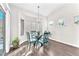 Bright dining area with a glass table, modern light fixture, and view of the backyard at 10725 Sky Meadows Ave, Las Vegas, NV 89134