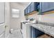 Bright laundry room features a modern washer and dryer with granite countertop and storage cabinets at 10725 Sky Meadows Ave, Las Vegas, NV 89134