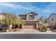 Two-story house with brown exterior, attached garage, and landscaped front yard at 1112 Via Monticano, Henderson, NV 89052