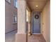 Gray front door with wreath, stone walkway, and a yellow welcome mat at 1112 Via Monticano, Henderson, NV 89052