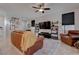 Living room with brown leather couches, large TV, and ceiling fan at 1112 Via Monticano, Henderson, NV 89052