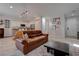 Living room with brown leather sofa, coffee table, and kitchen island view at 1112 Via Monticano, Henderson, NV 89052