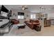 Open concept living room and kitchen with brown leather sofa and kitchen island at 1112 Via Monticano, Henderson, NV 89052