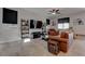 Living room with brown leather couches, large TV, and ceiling fan at 1112 Via Monticano, Henderson, NV 89052