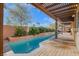 Long rectangular pool with a pergola and waterfall feature at 1137 Glistening Point Ave, Henderson, NV 89015