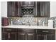 Modern wet bar with wine rack and hexagonal tile backsplash at 1557 Mistywood Ct, Henderson, NV 89014