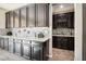 Elegant wet bar with wine rack and granite countertop at 1557 Mistywood Ct, Henderson, NV 89014