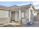 Front entrance of the house with a covered porch and a white door at 2687 Hollowvale Ln, Henderson, NV 89052