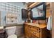 Rustic bathroom with unique sink, wood-paneled walls, and decorative mirror at 4187 Matterhorn Way, Mount Charleston, NV 89124