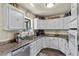 White kitchen with granite countertops and stainless steel appliances at 4187 Matterhorn Way, Mount Charleston, NV 89124