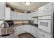 White kitchen cabinets, granite countertops, and modern appliances at 4187 Matterhorn Way, Mount Charleston, NV 89124