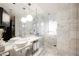 Luxurious bathroom with marble tiles, double sinks, and a glass shower at 4381 W Flamingo Rd # 28316, Las Vegas, NV 89103