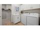 Well-organized laundry room with white cabinets, sink, and modern appliances at 5012 Notting Hill Ave, Las Vegas, NV 89139