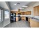 Modern kitchen with oak cabinets, granite counters, and black appliances at 5020 Valero Ct, Pahrump, NV 89060