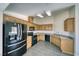 Modern kitchen with oak cabinets, granite counters, and black appliances at 5020 Valero Ct, Pahrump, NV 89060