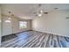 Bright and airy living room with wood-look floors and a ceiling fan at 5020 Valero Ct, Pahrump, NV 89060