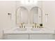 Double vanity bathroom with arched mirrors and updated fixtures at 5201 Rim View Ln, Las Vegas, NV 89130