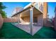 Backyard patio covered with awning and bordered by turf and a privacy fence at 5391 Kennedy Hill Ave, Las Vegas, NV 89139