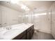 Modern bathroom boasts a double sink vanity, glass enclosed shower and tiled floors at 5391 Kennedy Hill Ave, Las Vegas, NV 89139