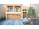 Two-story house with tan exterior, two-car garage, and balcony at 5391 Kennedy Hill Ave, Las Vegas, NV 89139