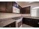 Dark wood kitchen cabinets, granite counters and appliances at 5391 Kennedy Hill Ave, Las Vegas, NV 89139