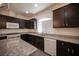 Kitchen featuring dark wood cabinets, stainless steel appliances and gray countertops at 5391 Kennedy Hill Ave, Las Vegas, NV 89139