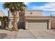 Two-story house featuring a tan stucco exterior and palm trees at 5458 Walton Heath Ave, Las Vegas, NV 89142