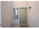 Light green front door with a sidelight window and outdoor light fixture at 5458 Walton Heath Ave, Las Vegas, NV 89142